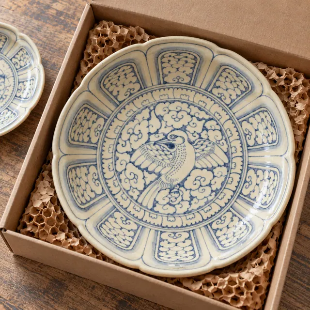 AI illustration: a bird-and-cloud ceramic dish protected by paper in a shipping box.